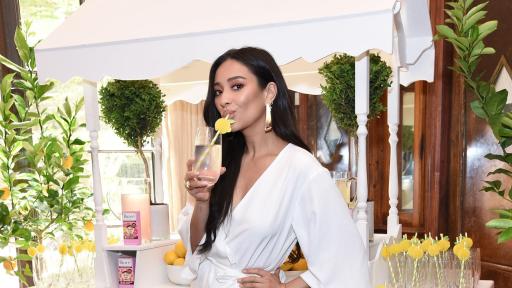 Shay Mitchell drinking a fruity drink.