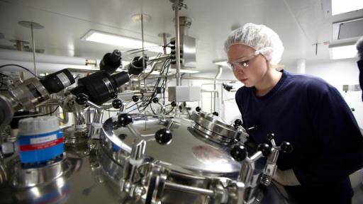 Woman looking into a centrifuge in the Influenza Plarkville vaccine lab