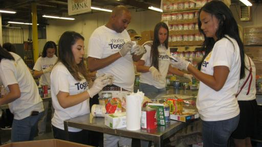 volunteer at a food bank boxing up supplies