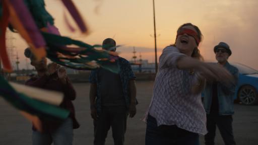 A woman with a blindfold hitting a Piñata