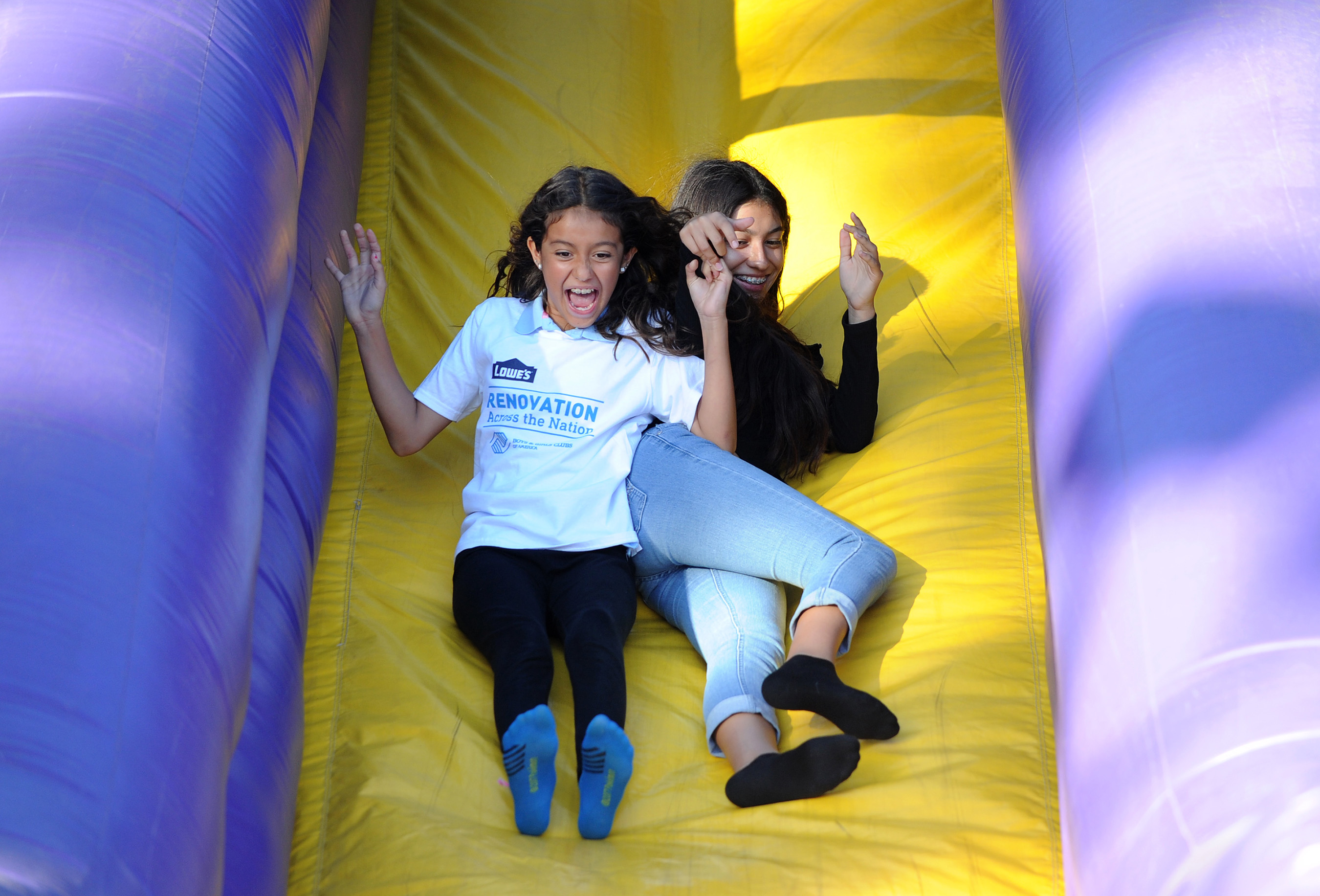 Boys & Girls Club of Long Beach members enjoy an inflatable slide during an event announcing the expansion of Renovation Across the Nation, the coast-to-coast renovation initiative powered by Lowe's employee volunteers and a $3.8 million donation.