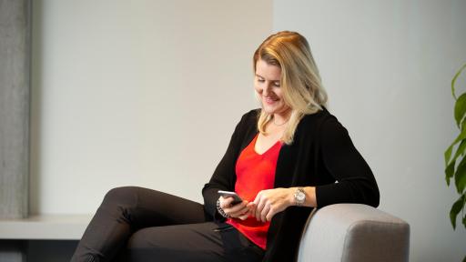 Hayley Wickenheiser sitting on sofa looking at iphone