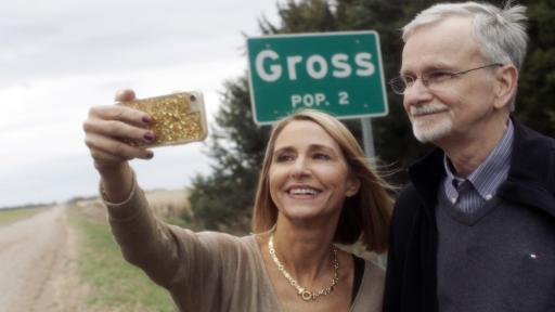 Woman and man taking a selfie in front of the Gross city sign
