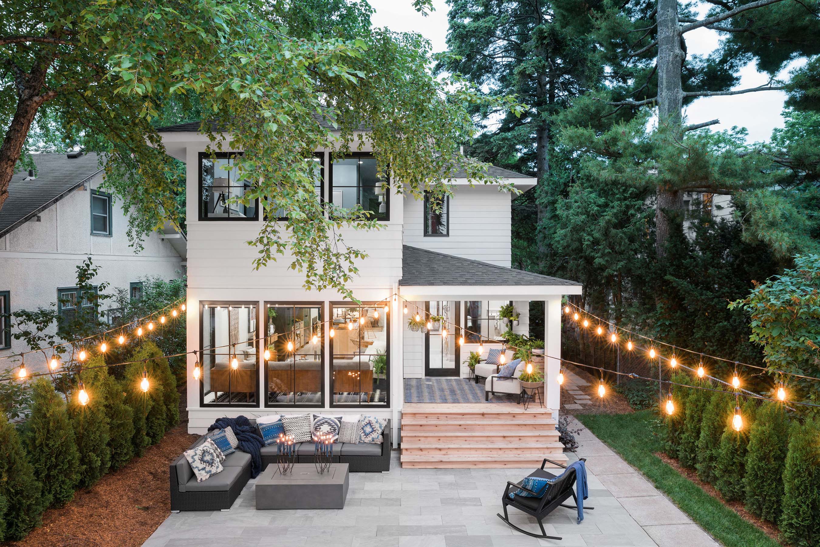 Oozing with midwestern hospitality, the backyard of the HGTV Urban Oasis 2019 is perfect for both relaxing and entertaining. The detached garage has been painted to add a backdrop reminiscent of Nordic fjords, while café lights add instant ambience.