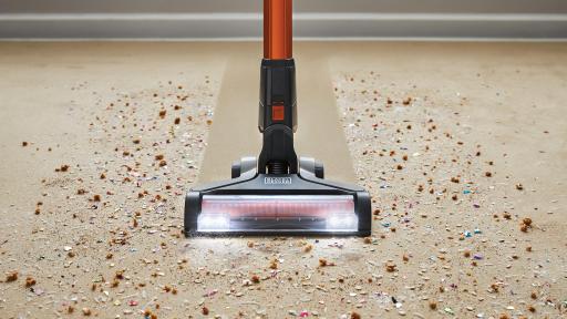 Cordless vacuum sweeping carpet.