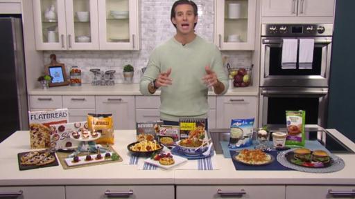 A man presents frozen food items sitting on a table in front of him