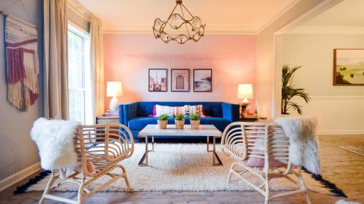 The living room, designed by Brittany Hayes of Addison’s Wonderland, features an inviting velvet couch in front of a light pink temporary wallpaper mural