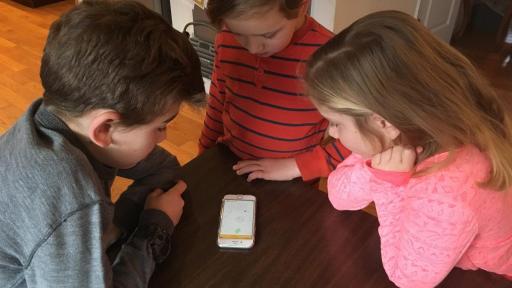 Three kids using the mobile app.