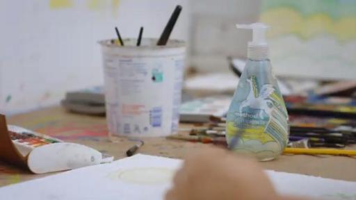 person drawing next to soap bottle