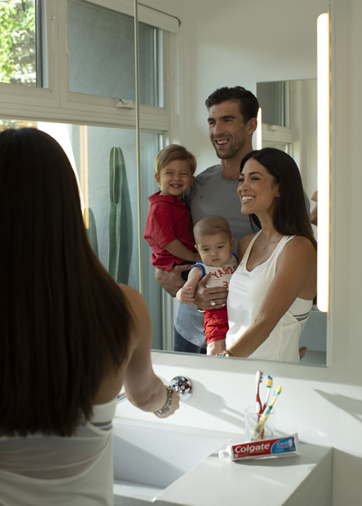 Michael Phelps teaches son Boomer (2) to turn off the faucet when brushing his teeth in support of Colgate's Save Water program.
