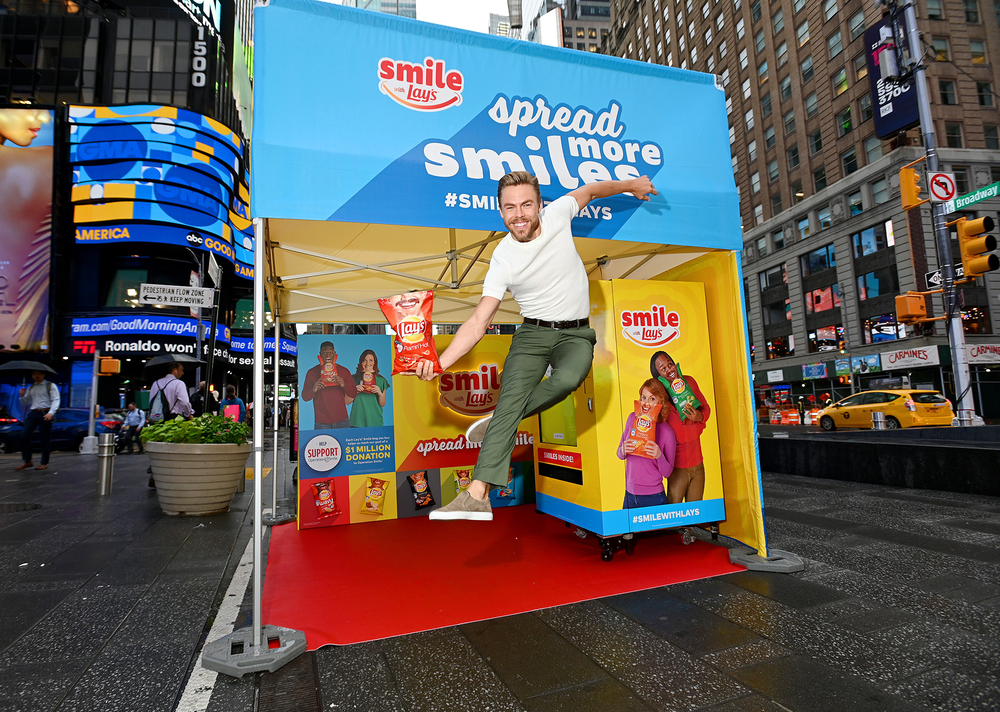 Dancer, actor and singer Derek Hough kicks off the Lay’s Smiles campaign by unveiling the first-ever Smiles Station in Times Square, New York City, on July 23, 2019. The station dispenses Lay’s limited-edition bags to passerby featuring real people’s stories and smiles aimed at helping raise $1 million to Operation Smile.