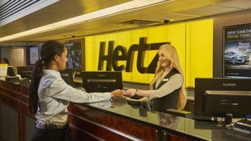 Hertz representative helpling customer at counter