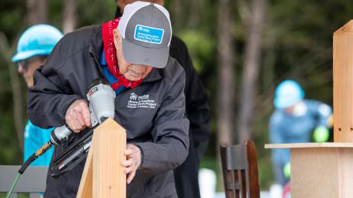 Jimmy Carter hammering two boards together for a house.