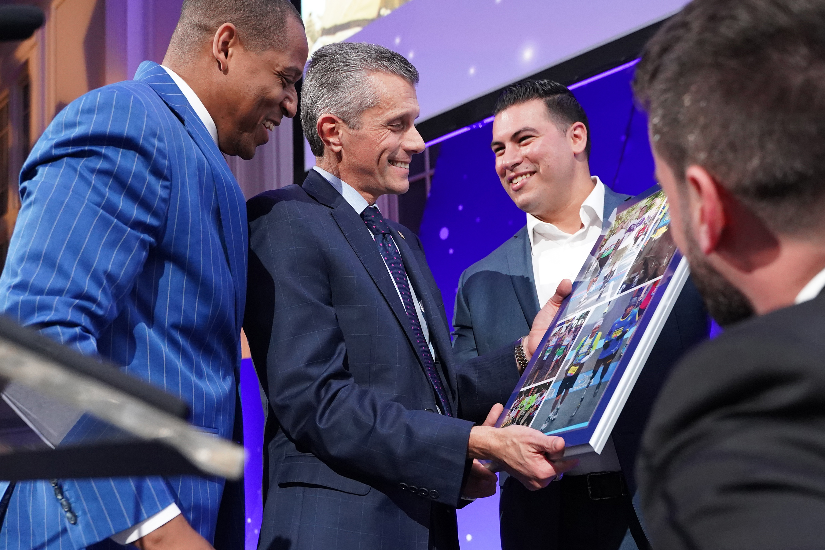 Achilles International Freedom Team members, Cedric King, Stefan LeRoy and Matias Ferreira, present the Volunteer of the Year award to David Cordani, President and CEO of Cigna.
