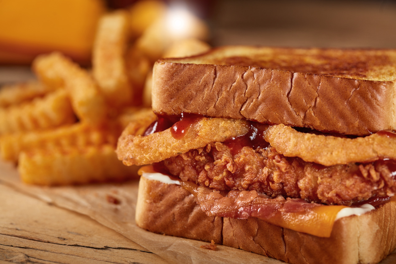 The Smokehouse Cheddar BBQ Fillet Sandwich features a hand-breaded fillet and is topped with onion rings, crisp bacon, cheddar cheese, savory barbeque sauce and mayonnaise on Texas toast.