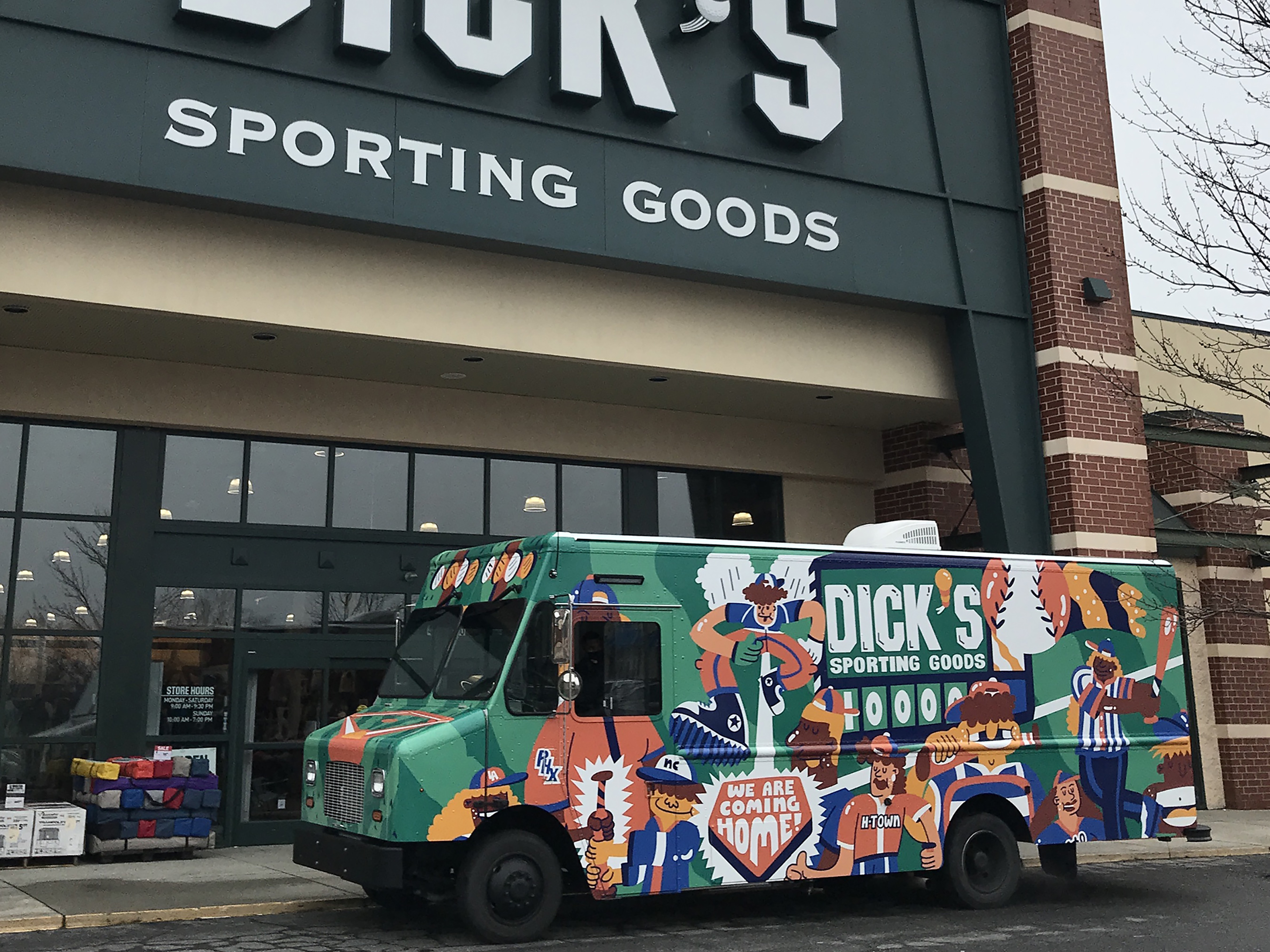 The DICK’S Sporting Goods truck parked in front of a DICK’S Sporting Goods store