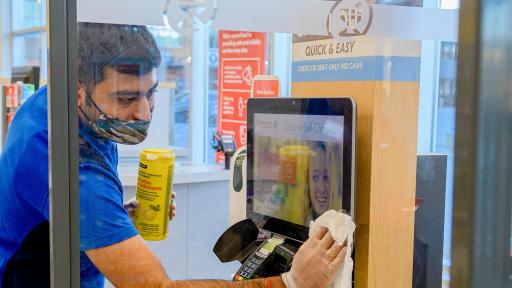 Shoppers Drug Mart employee sanitizes self checkouts