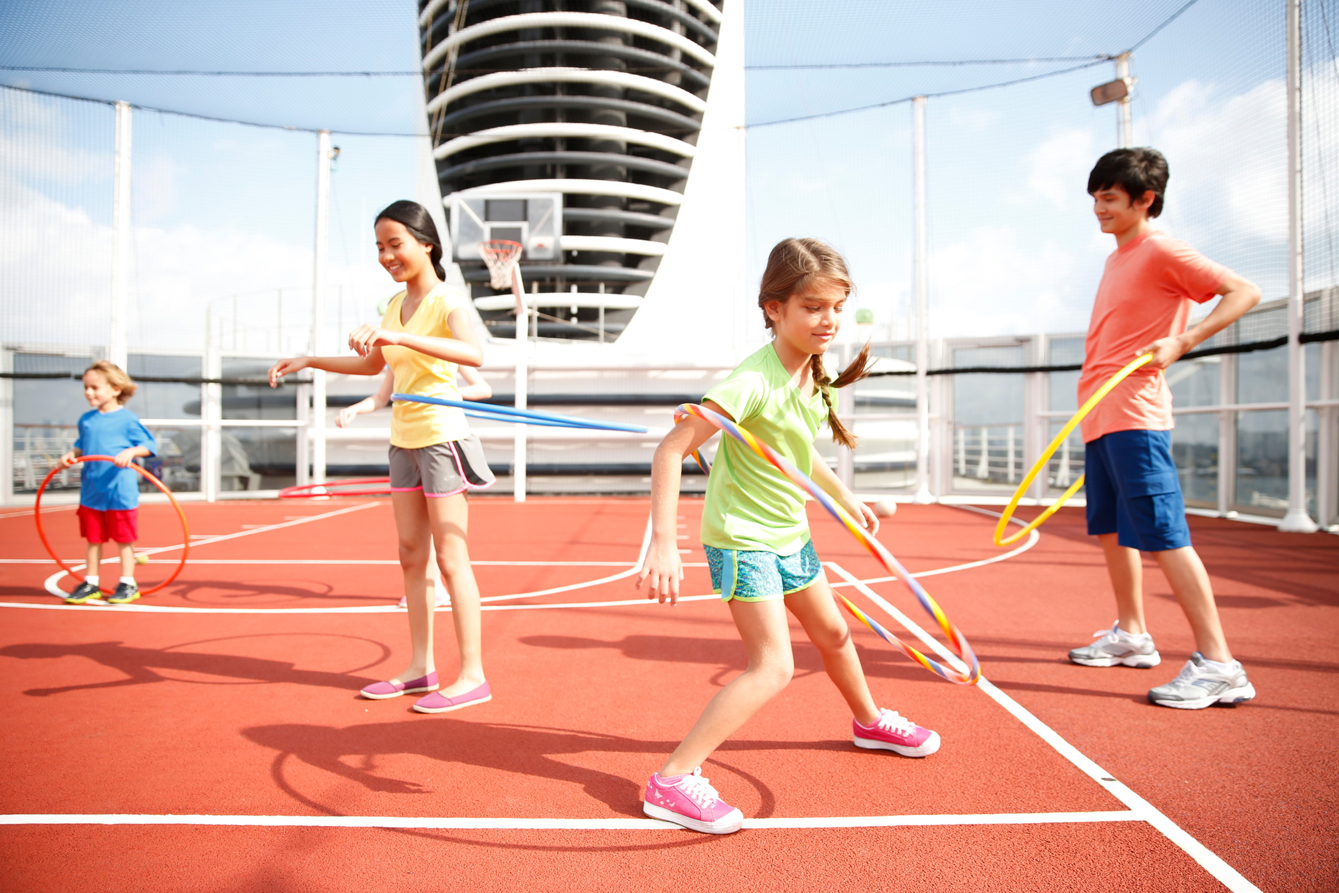 Kids have fun with Hula Hoops on the sports deck of Holland America Line’s cruise ship.