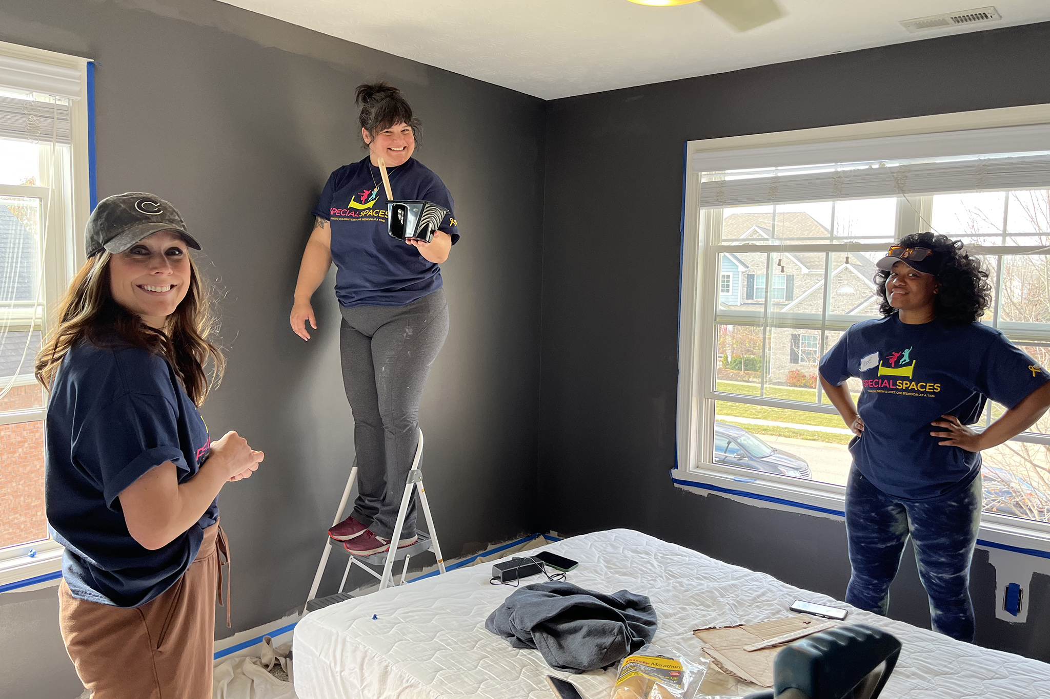Volunteers from Northwestern Mutual’s Indianapolis-based office painting Luke’s brother’s bedroom