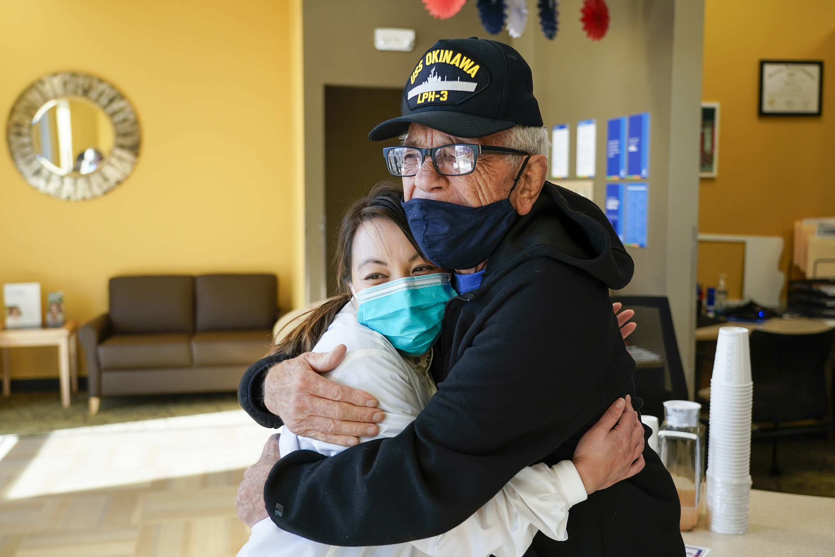 Navy veteran Kenny Jary hugs Linh Tran, D.D.S. after getting a new set of teeth at Aspen Dental, Saturday, Nov. 6, 2021, in Forest Lake, Minn. (Craig Lassig/AP Images for Aspen Dental)