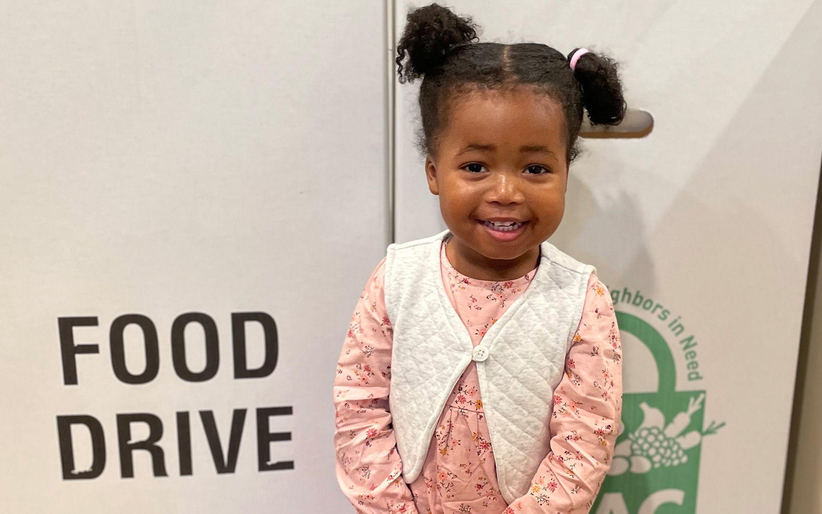 A young student at Primrose School of Arlington (Arlington, VA) participates in the Caring and Giving Food drive by donating an assortment of nonperishable food items.