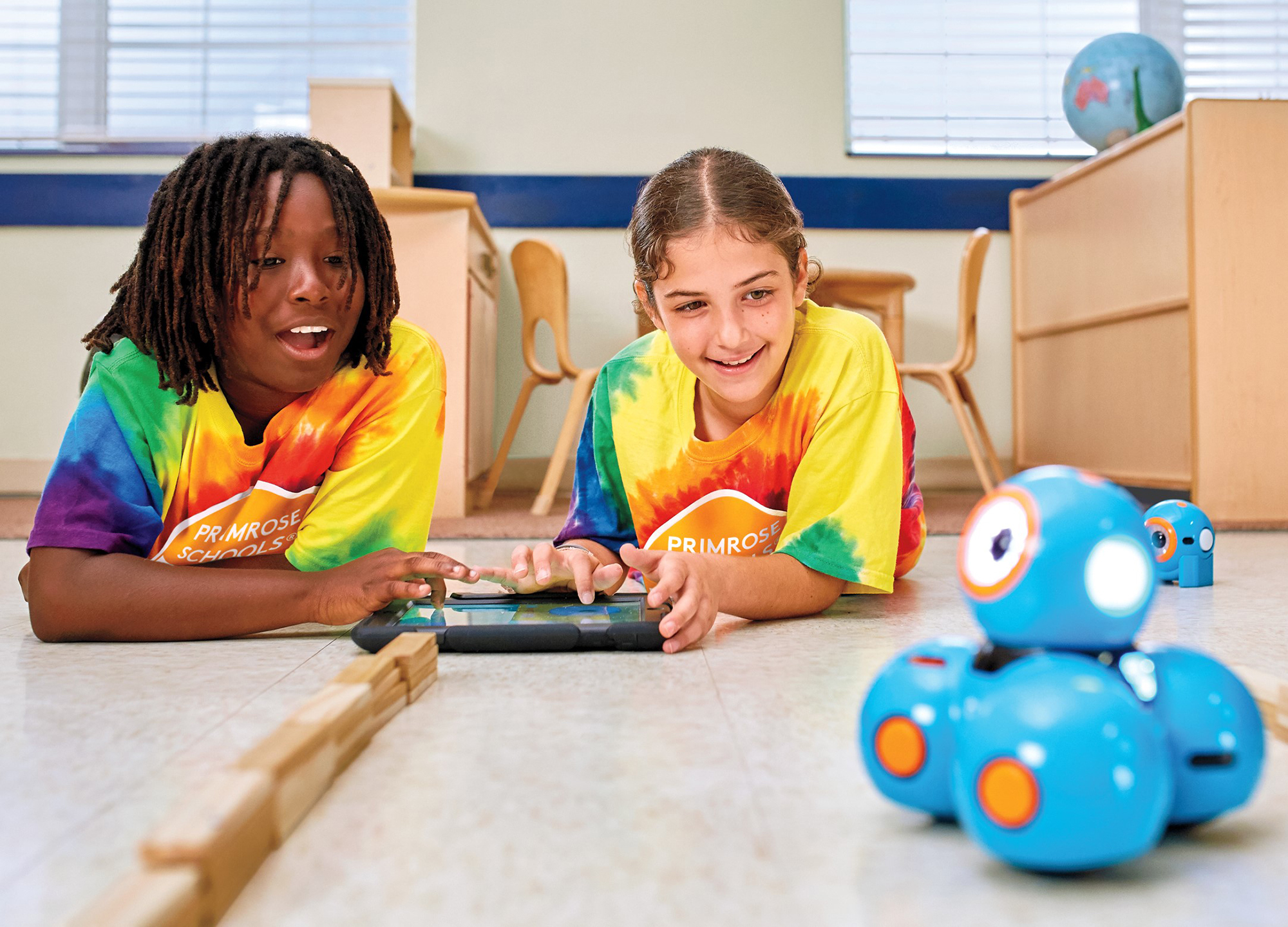 Children interact with a programmable robot named Dash through coding, mazes and special missions at the Primrose Schools Summer Adventure Club, furthering STEM-based learning and robotics education.