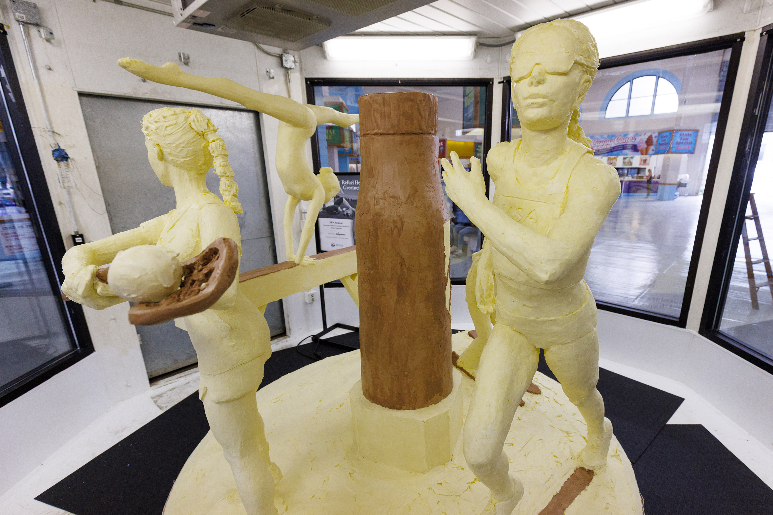 American Dairy Association North East unveiled the 54th Annual Butter Sculpture at the New York State Fair on August 23, 2022, titled Refuel Her Greatness – Celebrating the 50th Anniversary of Title IX. The sculpture spotlights female athletes and how today’s athletes refuel with chocolate milk and features a progression of female athletes ranging in age from a child skier to a high school-aged gymnast to a college lacrosse player to an adult runner.
