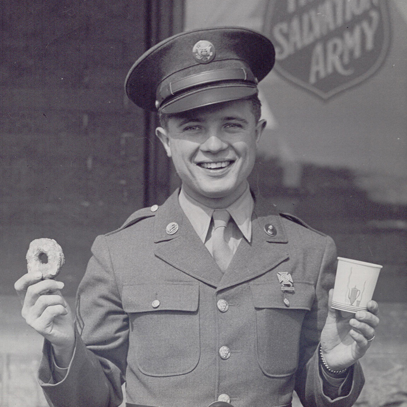 Serviceman holding donut and coffee