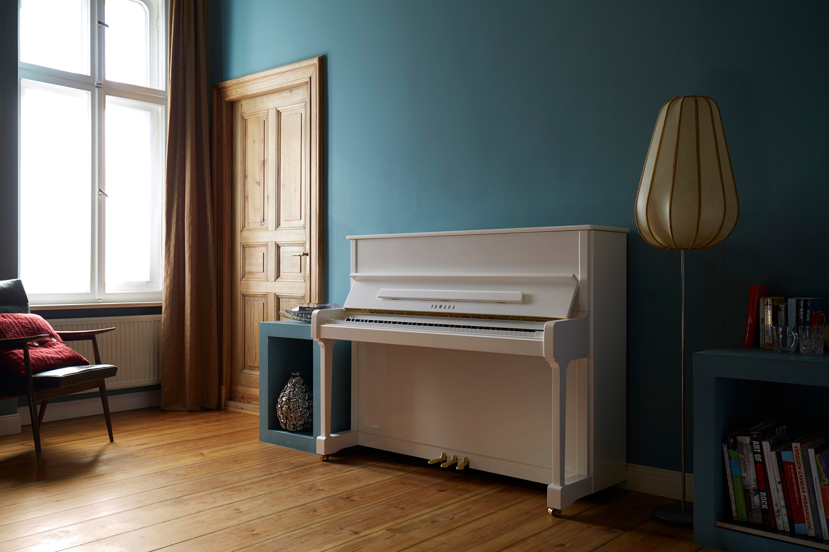 White piano against a blue wall