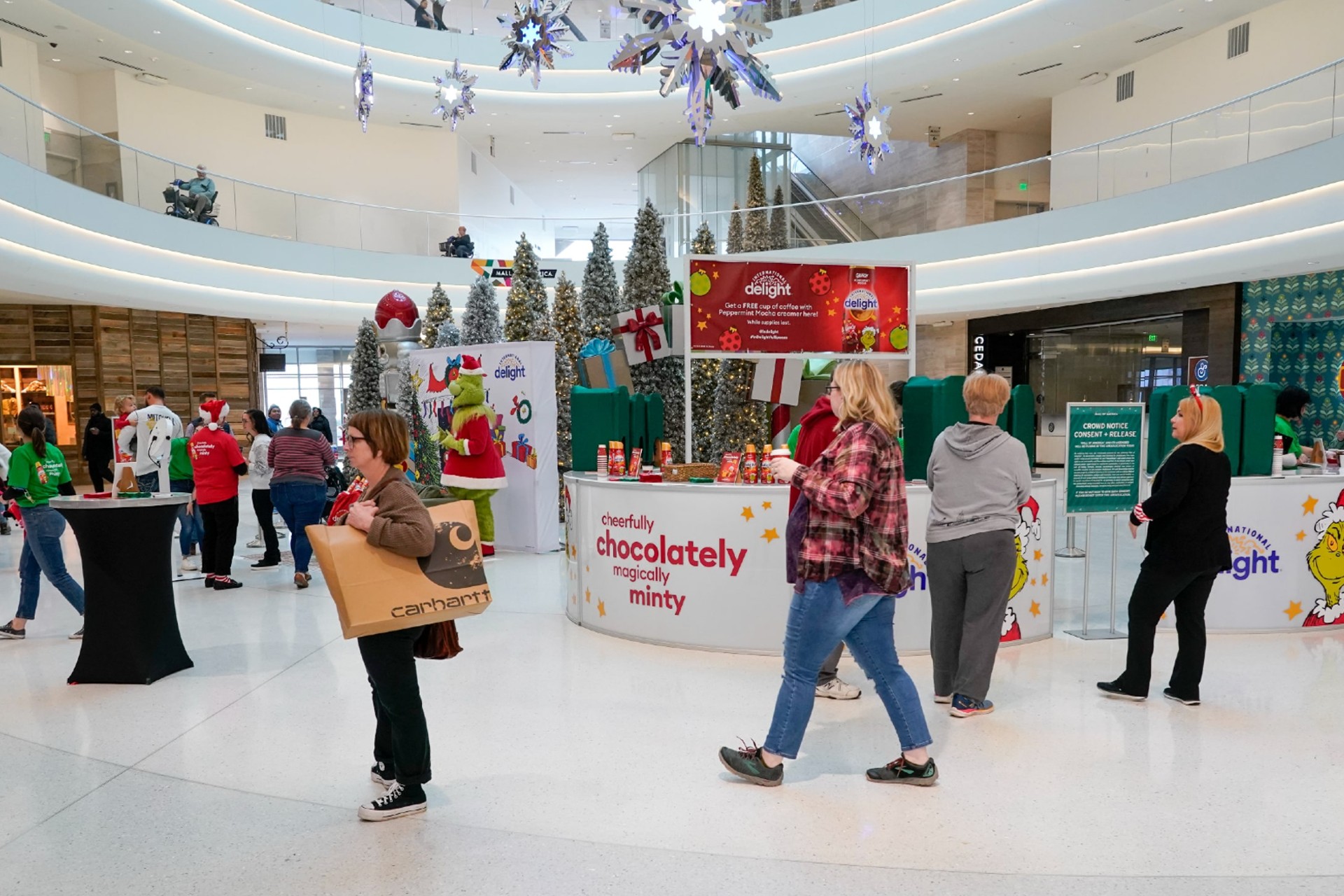 International Delight surprises and delights shoppers with free coffee and Grinch-themed Peppermint Mocha creamer at Mall of America on Thursday, Dec. 8, 2022, in Minneapolis.