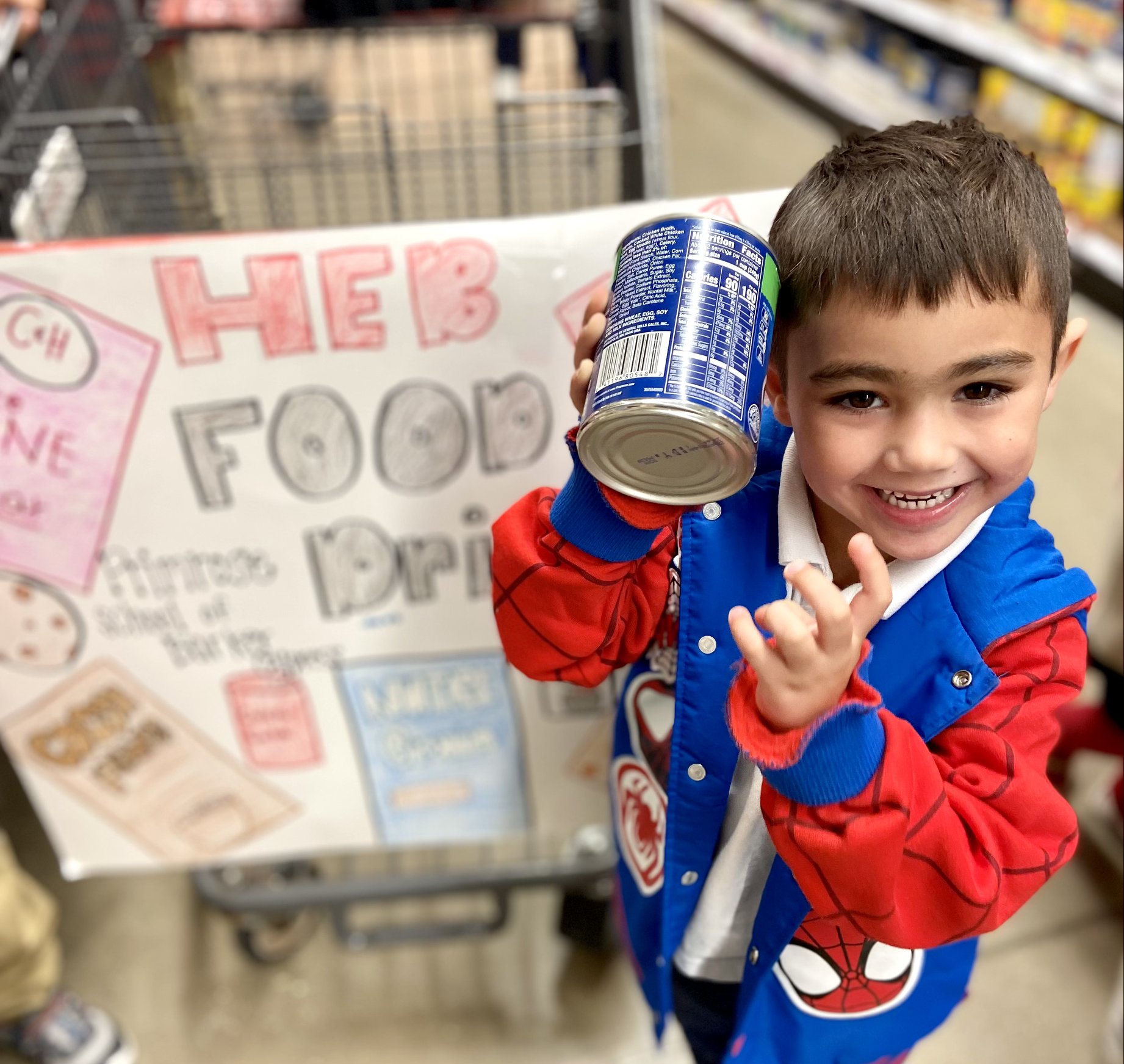 A student from Primrose School of Barker-Cypress (Cypress, TX) takes a field trip to a local grocery store to shop for items to donate during the Caring and Giving Food Drive.