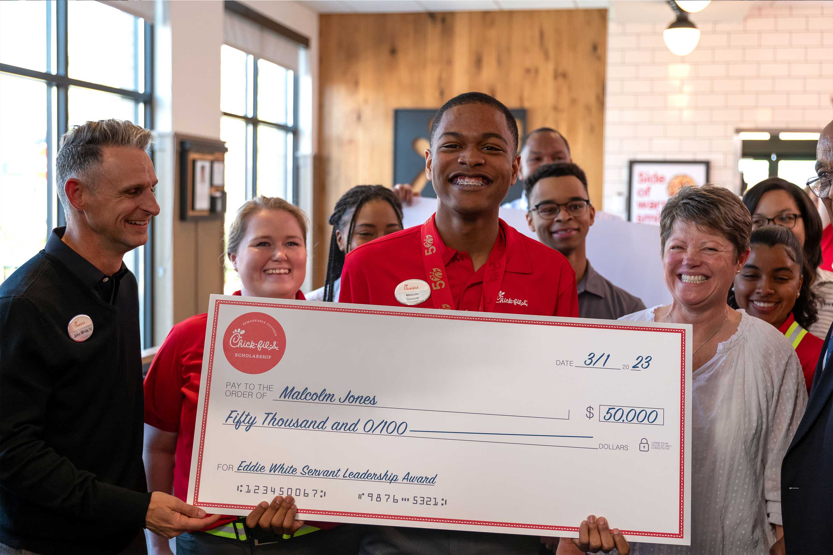 Chick-fil-A restaurant Team Member Malcolm Jones, of Wilson, N.C., was surprised with the one-time Eddie White Servant Leadership Award for $50,000 ─ the largest scholarship in Chick-fil-A history – in honor of 50 years of scholarship giving at Chick-fil-A.