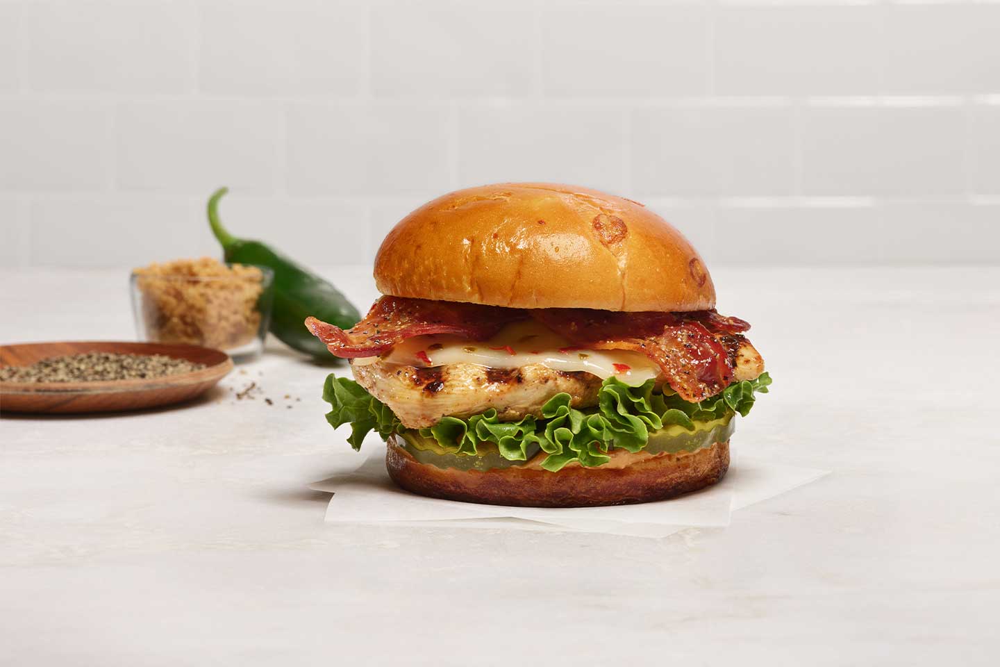 The Maple Pepper Bacon Sandwich is made with a lemon herb marinated boneless breast of chicken, grilled for a tender and juicy backyard-smoky taste.