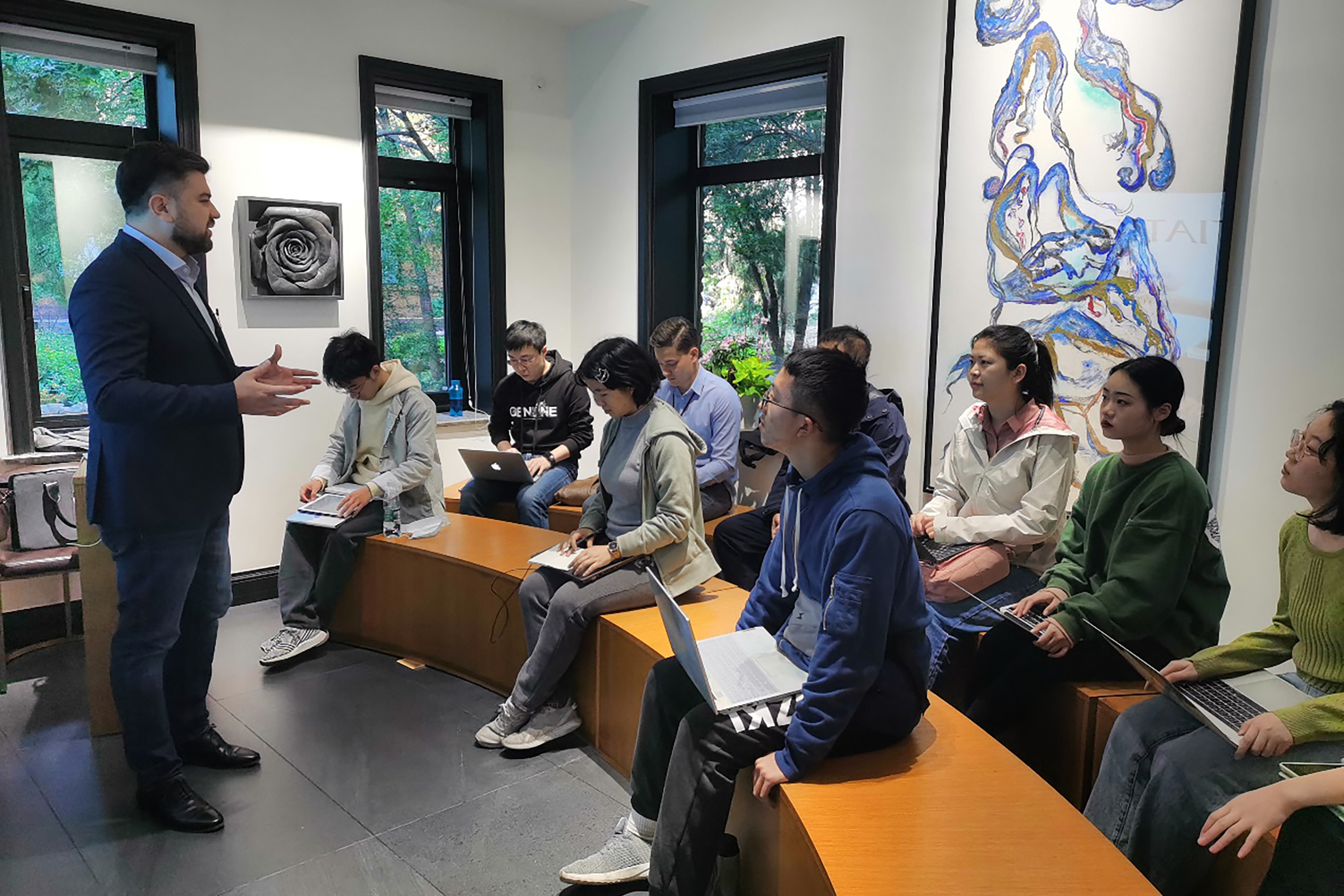 A lecturer passionately teaching a group of attentive students at Tsinghua University.