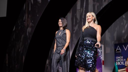 Las representantes de Avon Natasha Lightner y Alicia Hessinger caminan por la pasarela luciendo la colección de mark. by Avon para la época de fiestas en el Avon RepFest 2018.