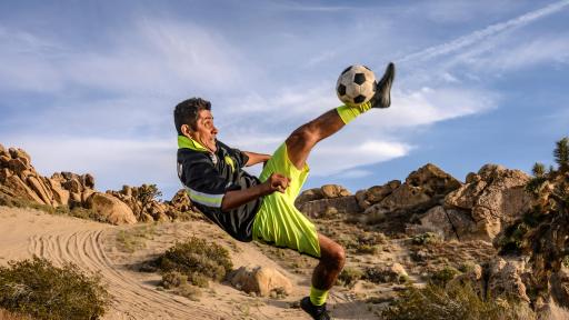 Campos kicking a soccer ball in the desert