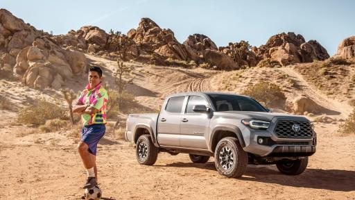 Campos standing by a Tacoma in the desert
