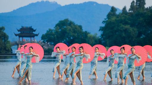 500 Frauen, alle ein Qipao tragend, tanzen im Einklang an Hangzhous Wahrzeichen