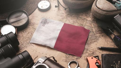 Image of Malta flag, travelers accessories, an old vintage map - tourist destination concept.