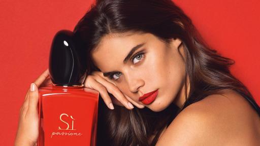 Model, Sara Sampaio, holding a bottle of Si Passione in her lap