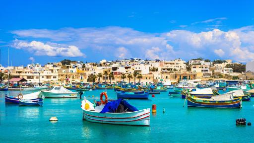 Image of Marsaxlokk village with traditional colorful fishing boats luzzu Malta